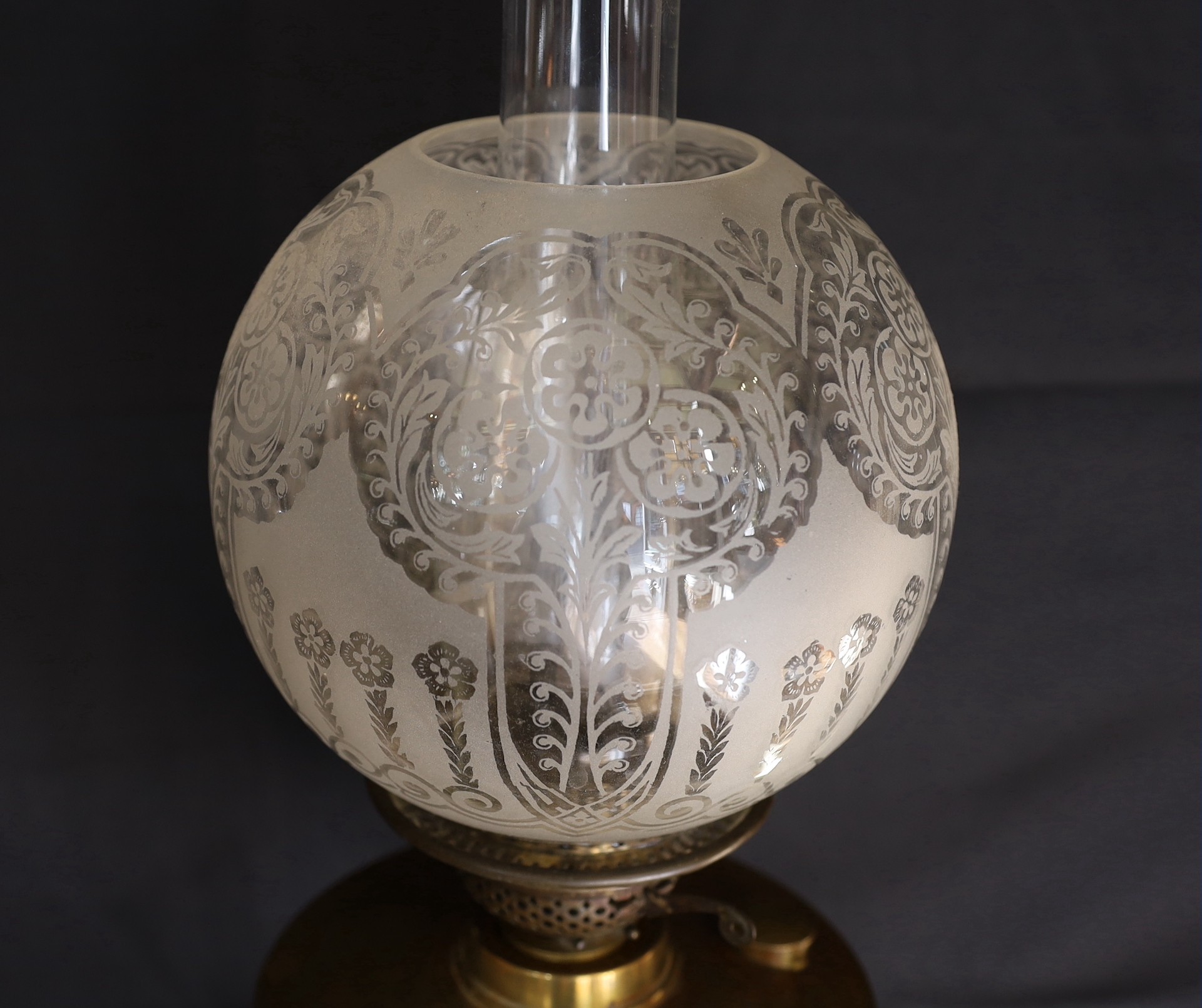 An Edwardian brass oil lamp, with etched glass globe, duplex mechanism and Art Nouveau embossed base, height to top of shade 58cm